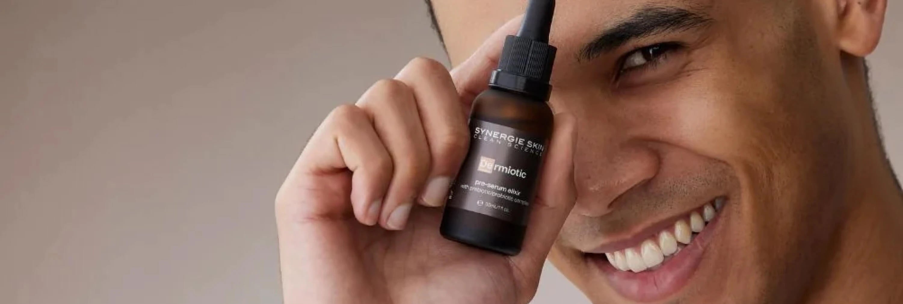 Skincare model holding Synergie Skin's Dermiotic near face